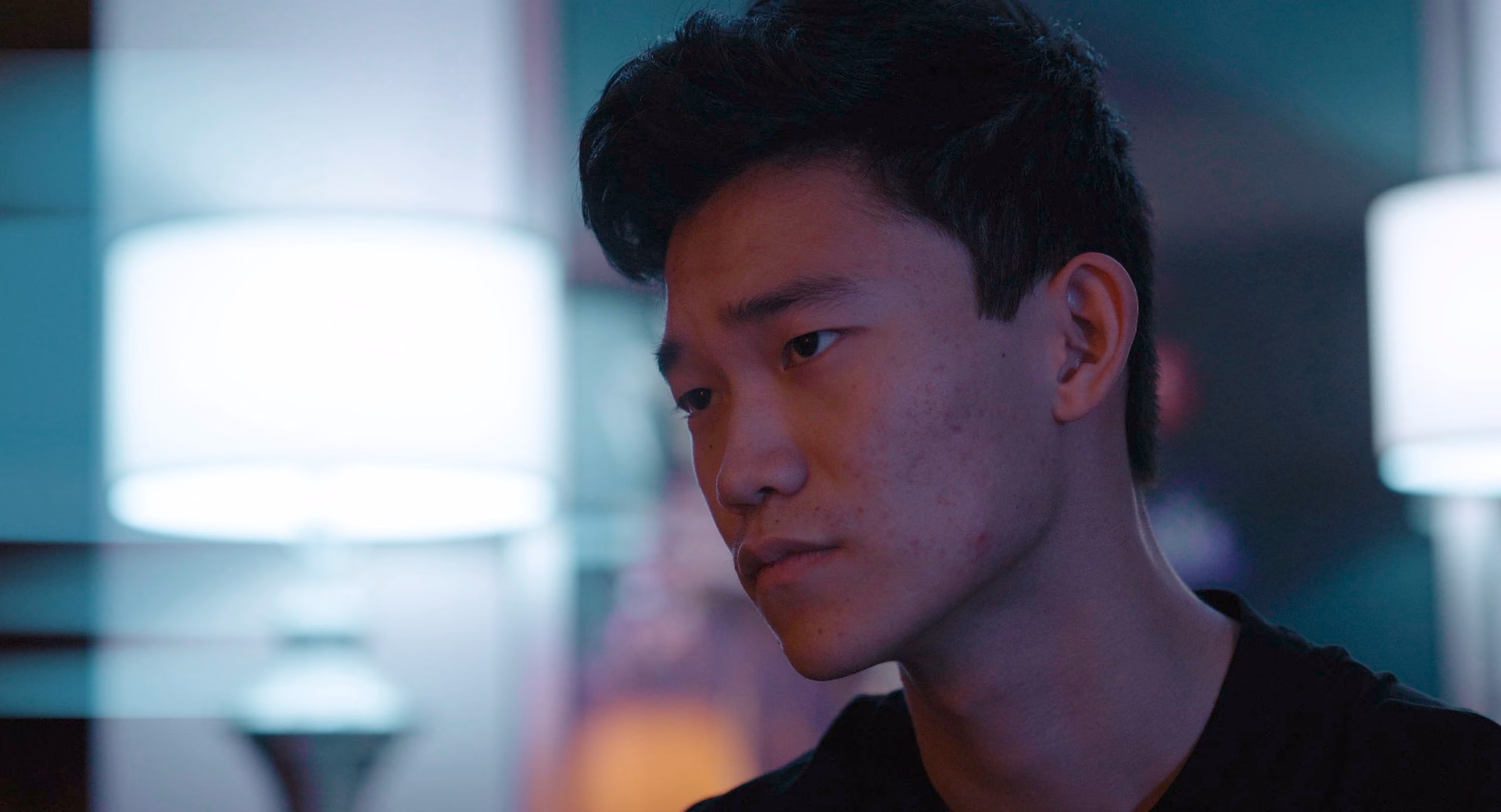 A young man in blue and red light in Murder of Minus
