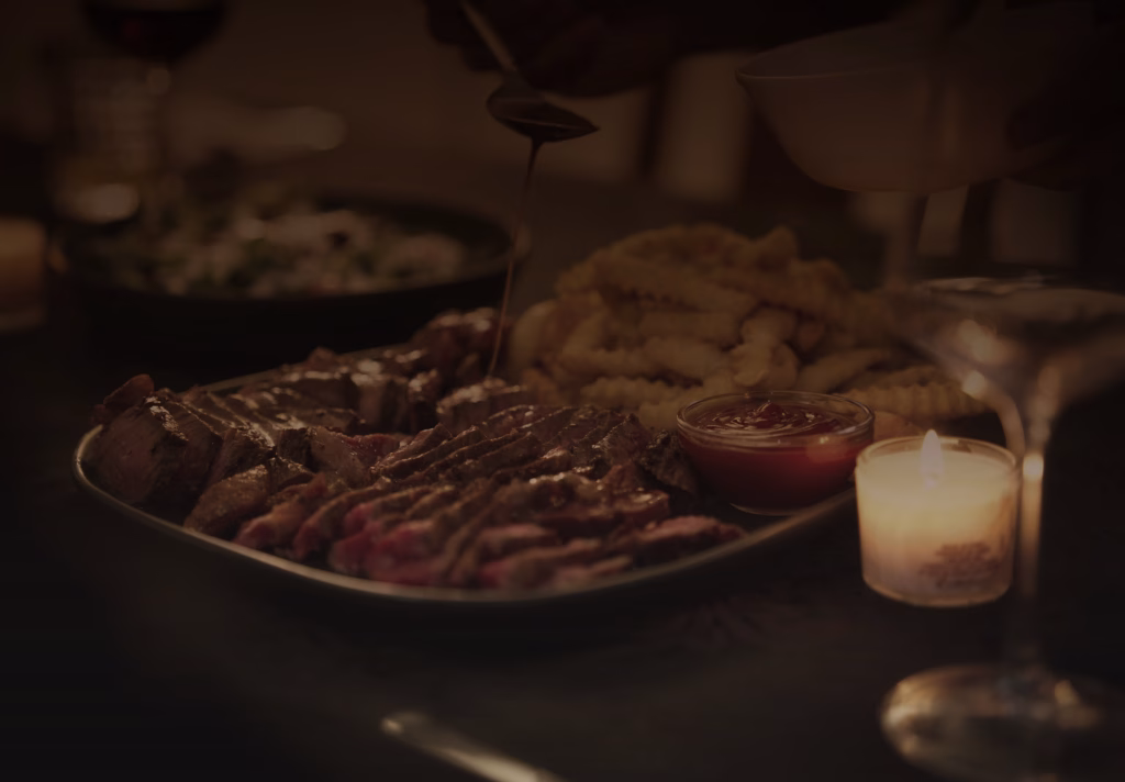 Steak and fries served by candlelight at Searing Stories